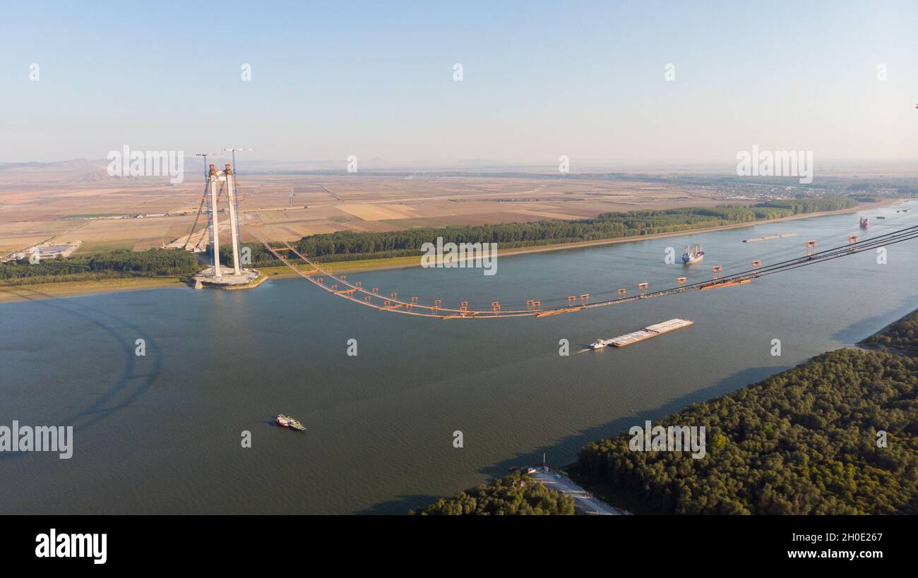 Panorama-Drohnenaufnahme von oben auf der schwebenden Brücke über die donau, die im Bau ist, zwischen Braila und Tulcea Städten in Rumänien Stockfoto