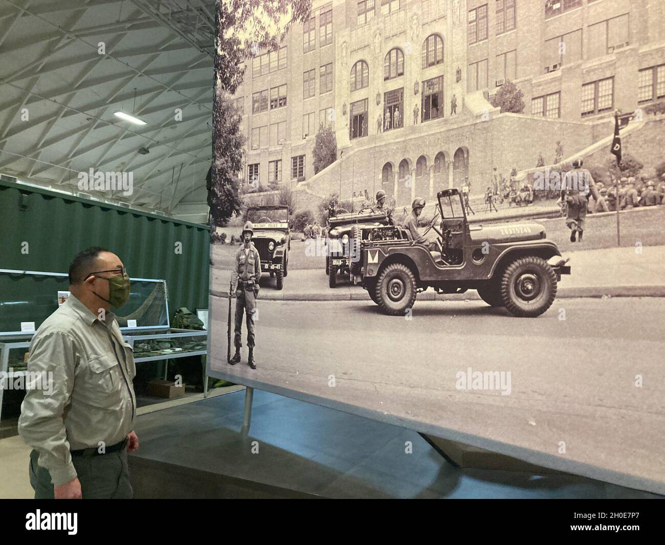Tom Hara, Manager des Dreyer Field House, passiert ein großes Foto von Soldaten der Little Rock Central High School und der 101. Airborne Division (Air Assault), die nach dem Brown vs. Board of Education von Topeka zum Schutz der Little Rock Nine beigetragen haben. Etwa 600 101. ABN. Div. Soldaten, die der Luftlandegruppe 1-3 zugewiesen wurden, wurden für etwa drei Monate eingesetzt, um die neun schwarzen Studenten vor Protestierenden zu schützen, sagte John O’Brien, Direktor der Brigg. General Don F. Pratt Memorial Museum. Stockfoto