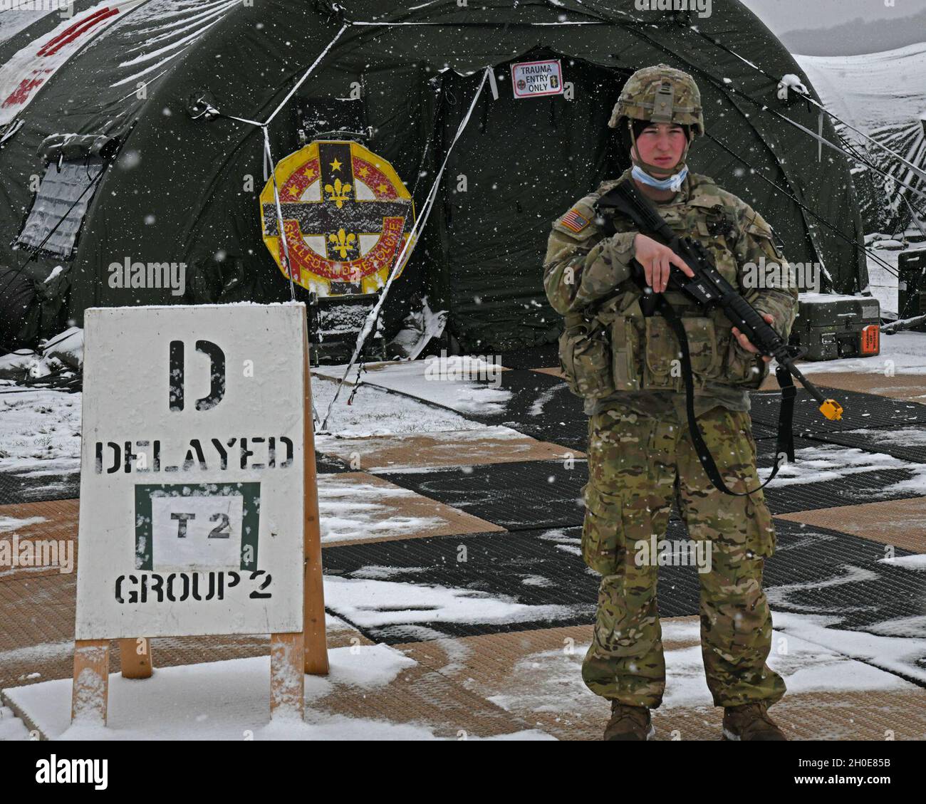 Ein Soldat mit der 512. Field Hospital Wache vor dem erste-Hilfe-Stationszelt auf ankommende Verwundete während eines Kampfunterstützungstrainings auf dem Flugplatz des Baumholder Manöver Training Area. Baumholder, Deutschland 8. Februar 2021 Stockfoto