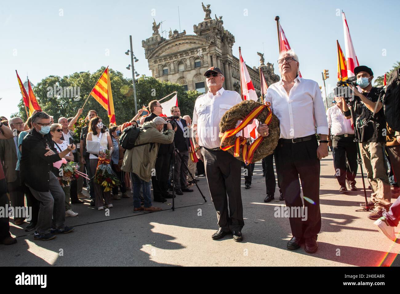 Barcelona, Spanien. Oktober 2021. Männer werden mit Kränzen an der Statue von Christoph Kolumbus in Barcelona gesehen.Menschen haben an der Blumengabe zur Statue von Christoph Kolumbus in Barcelona anlässlich des 12. Oktober, dem Hispanic Day, der von der rechtsextremen Partei VOX organisiert wurde, teilgenommen. Es gab den VOX-Sprecher im katalanischen Parlament, Ignacio Garriga, begleitet von den beiden Sprechern der katalanischen Kammer, Juan Garriga und Antonio Gallego, sowie dem Abgeordneten Andres Bello. (Foto von Thiago Prudencio/SOPA Images/Sipa USA) Quelle: SIPA USA/Alamy Live News Stockfoto