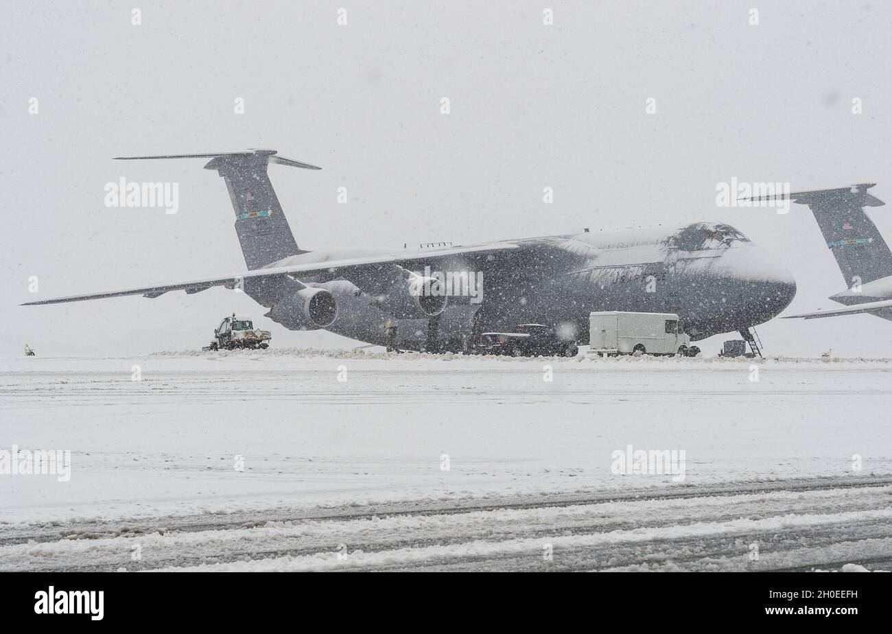 Eine schneebedeckte C-5M Super Galaxy, die für den Start vorbereitet wird, sitzt auf der Fluglinie auf der Dover Air Force Base, Delaware, 11. Februar 2021. Als der Wintersturm Roland eine winterliche Niederschlagsmischung produzierte, setzte die Basis den normalen Betrieb fort und bereitete sich auf zusätzliche prognostizierte Schneefälle vor. Stockfoto