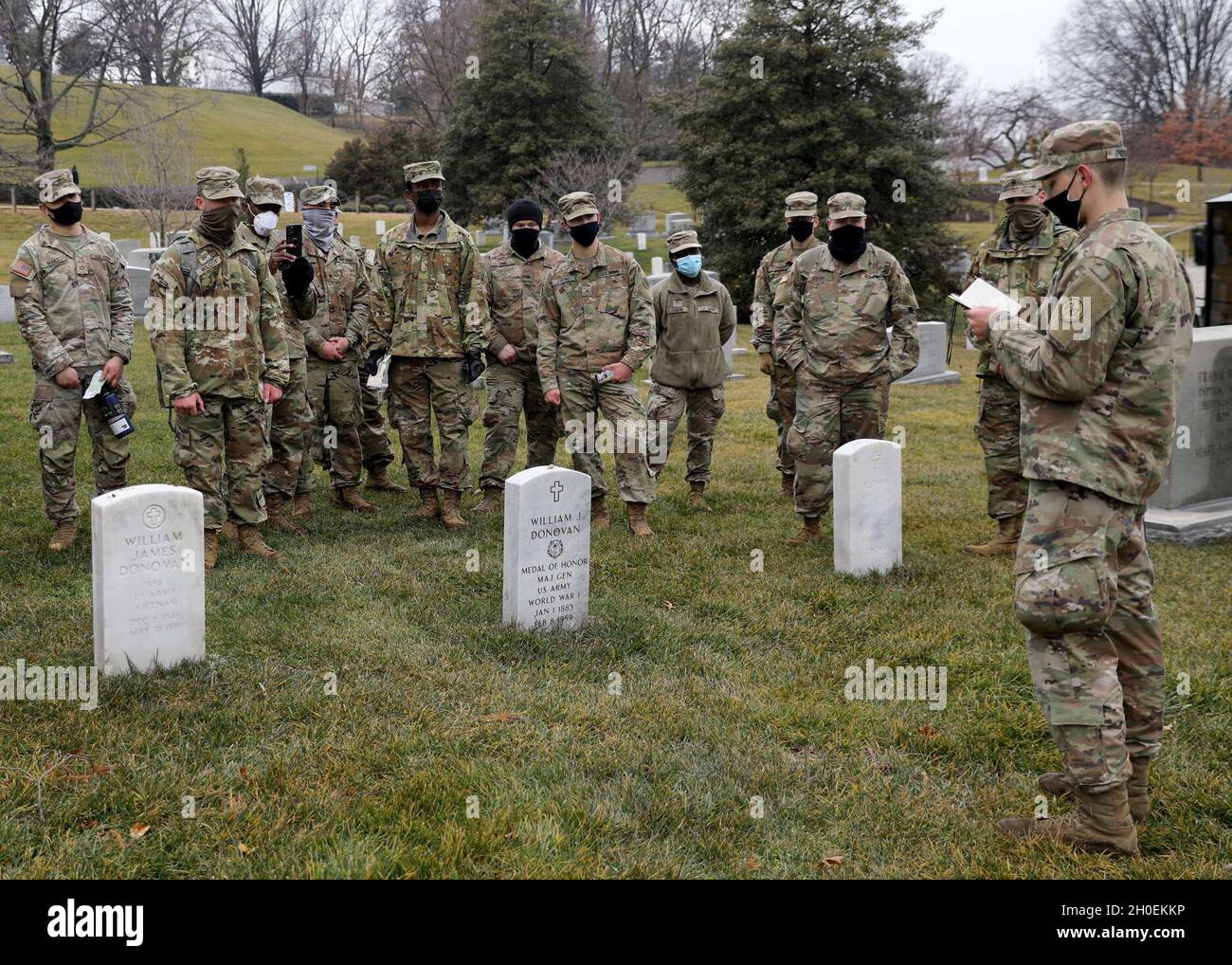 SPC der US-Armee. Rory Endsley, rechts, ein Infanterist mit Bravo Company, 2. Bataillon, 108. Infanterie-Regiment, 27. Infanterie-Brigade-Kampfteam, 42. Infanterie-Division, New York National Guard, Und Pulaski, gebürtiger New Yorker, spricht über den historischen Träger der Ehrenmedaille, Maj. General William, „Wild Bill“ Donovan, während eines hochrangigen, von Leiters vereißten Besuches auf dem Arlington National Cemetery in Arlington, VA., 14. Februar 2021. Donovan, der später als Leiter des Büros für strategische Dienste, dem Vorläufer der CIA, fungieren sollte, erhielt für seine Taten die Ehrenmedaille, während er das 165. Regiment befehlig Stockfoto