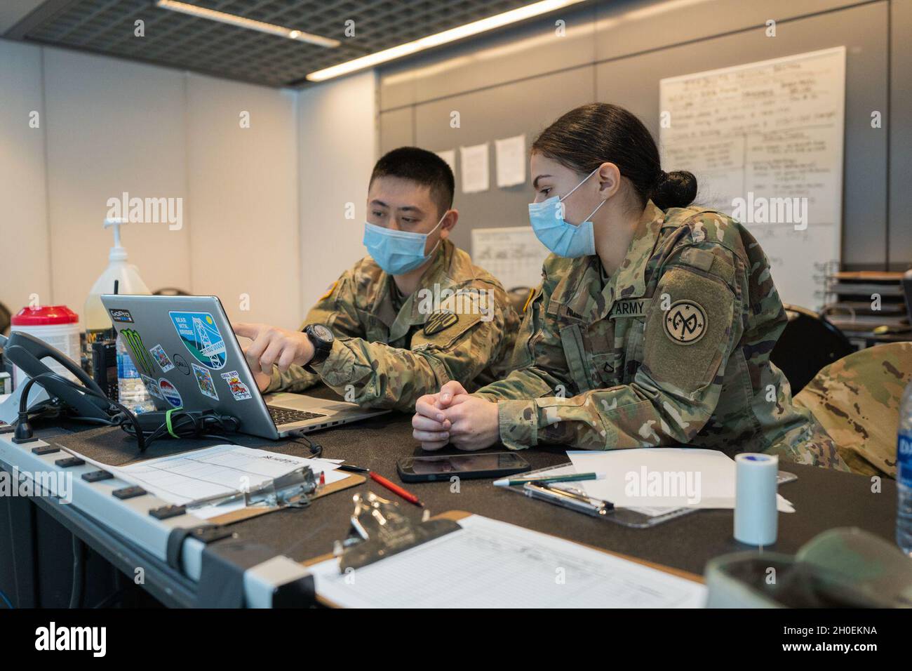 SPC der US-Armee. Chan Lau, der der 369th Sustainment Brigade des Hauptquartiers und der Headquarters Company zugewiesen wurde, und PFC. Victoria Nizzo, die dem Hauptquartier und der Hauptverwaltung der Kompanie 1. Bataillon 69. Infanterie-Regiment, dem Kampfteam der 27. Infanterie-Brigade, der 42. Infanterie-Division, zugewiesen wurde, überprüft die Verfahren zur Eingabe medizinischer Daten, um die staatlichen Bemühungen zur Bereitstellung von Massen-COVID-19-Impfungen zu unterstützen, die vom New Yorker Gesundheitsministerium durchgeführt werden, Im Javits Convention Center in Manhattan, New York, 14. Februar 2021. In der Nationalgarde sind Hunderte von Wachmännern und Frauen für die Impfung eingesetzt Stockfoto