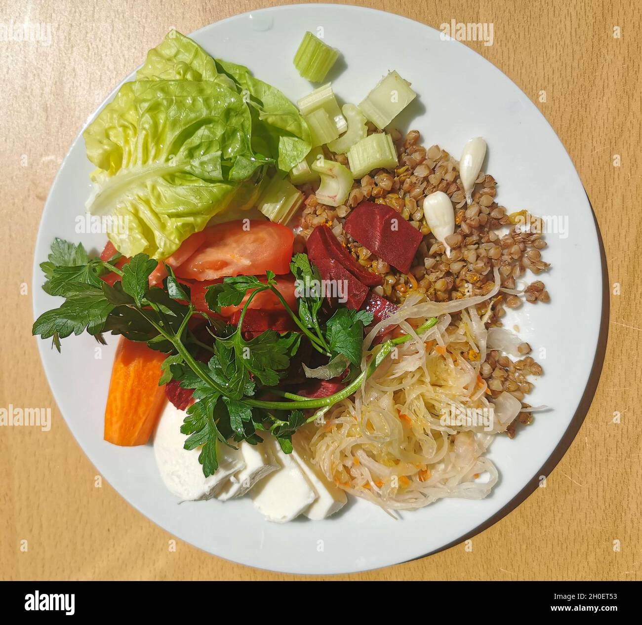 Ein gesundes, leckeres Frühstück mit Eiweiß, Fett und Kohlenhydraten. Buchweizenbrei mit Mocarella-Käse, Sauerkraut, Knoblauch Stockfoto