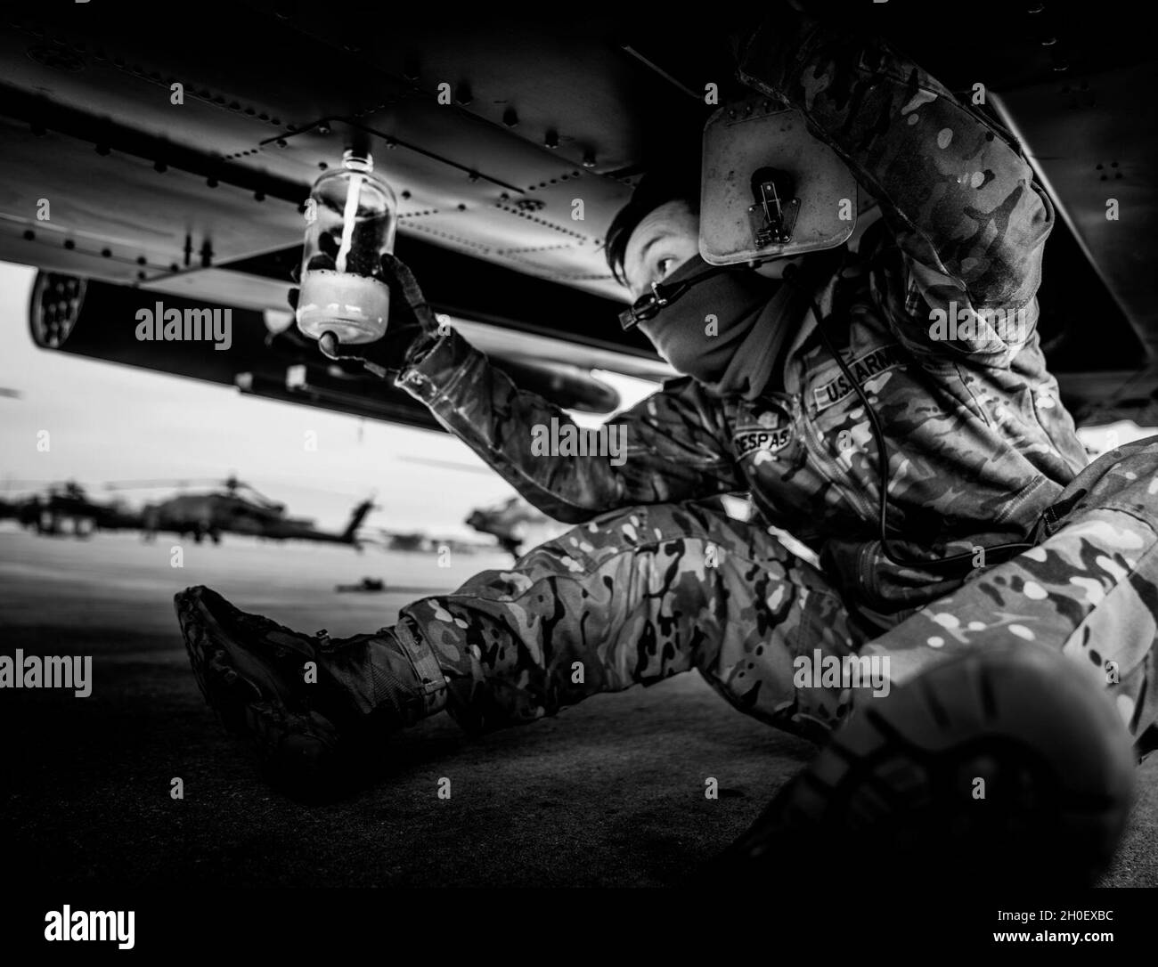 12. Combat Aviation Brigade AH-64 Crewchef SPC. Jackson Despas zieht am 18. Februar während der Vorflugkontrollen seines Apache-Angriffshubschraubers auf dem Flugplatz der Armee Katterbach, Deutschland, eine flüssige Probe. Stockfoto