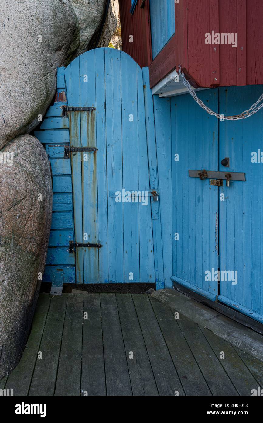 Eine alte blaue Holztür neben einer Felsformation. Bild aus der schwedischen Felseninsel Smogen Stockfoto