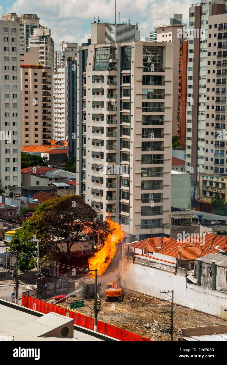 Feuerwehrleute, die einen Brand bekämpfen, der durch ein Gasleck in einer Straße von São Paulo verursacht wurde. Die Stadt, die für ihre kulturelle und geschäftliche Berufung in Brasilien bekannt ist. Stockfoto
