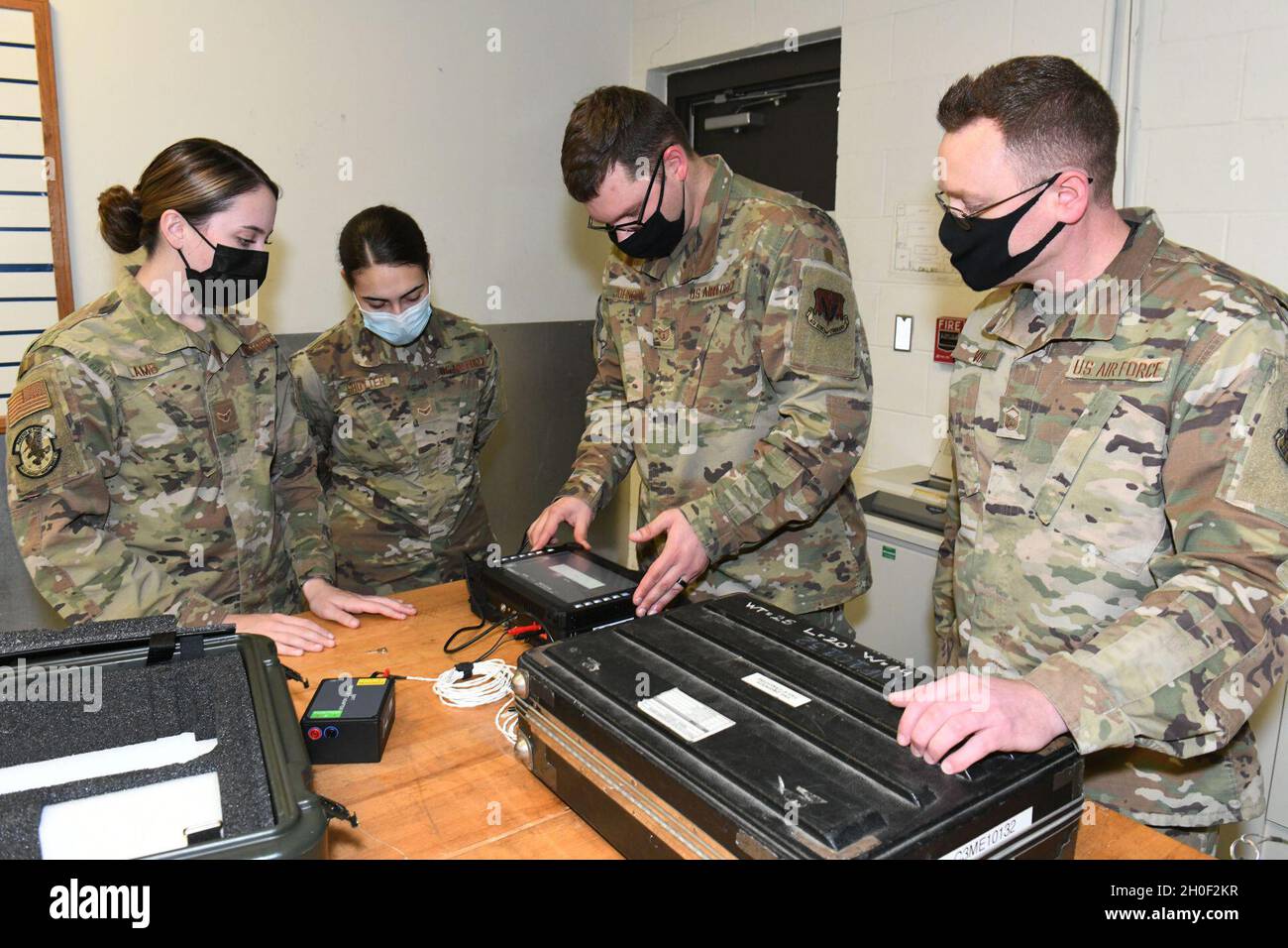 Technik. Sgt. Bradley Johnson, Center, 461st Aircraft Maintenance Squadron Instruments and Flight Controls Specialist und Gründer der Data Electronic Signal Working Group, zeigt, wie ein Spread-Spectrum-Time-Domain-Reflektometer auf der Robins Air Force Base, Georgia, eingerichtet werden kann, 19. Februar 2021. Die DESWG, bestehend aus Airmen, die sich zusammenschlossen, um bessere, schnellere und stärkere Wege zur Kabelwartung zu finden, arbeitete an der SSTDR, die mehrere Wellen aussendet und Reparaturen innerhalb von drei Metern identifiziert. Stockfoto