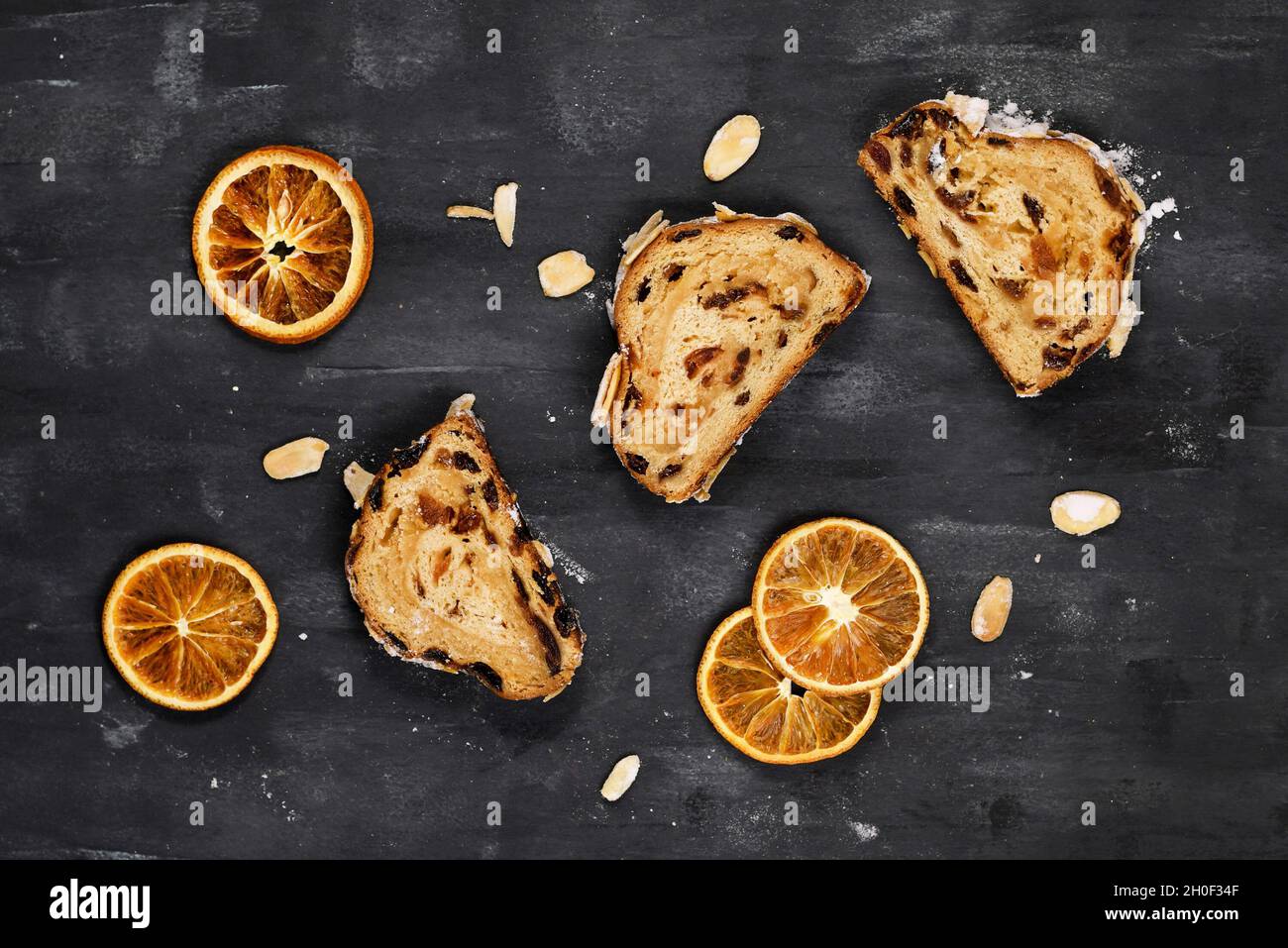 Draufsicht auf ein Stück deutscher Stollenkuchen, ein Obstbrot mit Nüssen, Gewürzen und getrockneten Früchten mit Puderzucker, das traditionell zu Weihnachten serviert wird Stockfoto