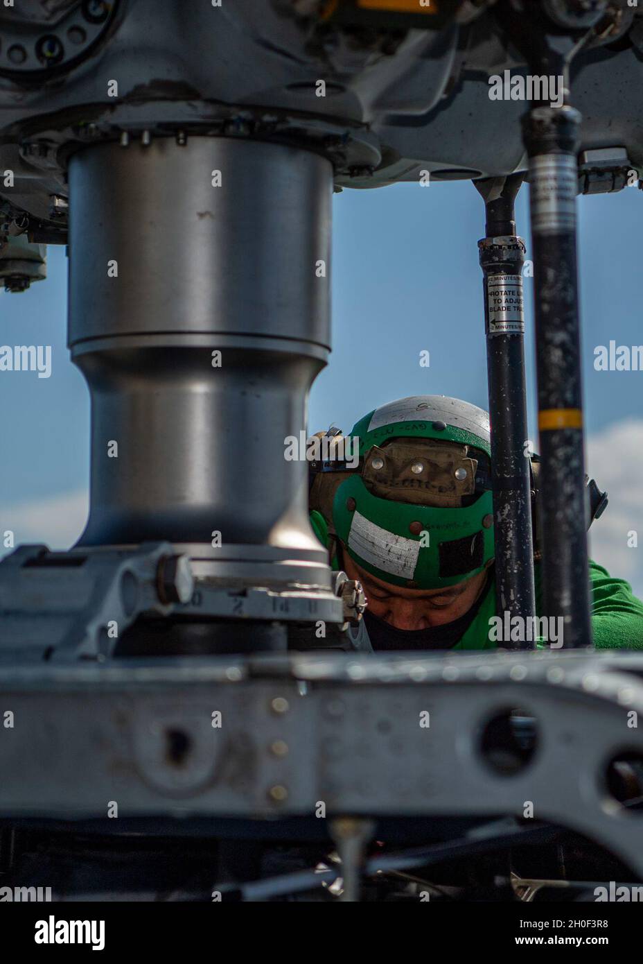 PAZIFISCHER OZEAN (Feb 20, 2021) U.S. Navy Aviation Structural Mechanic 2nd Class James Han, aus Tian Jin, China, zugewiesen an die „Magier“ des Helicopter Maritime Strike Squadron (HSM) 35, blutet die Rotorbremse auf einem MH-60R Sea Hawk auf dem Flugdeck des Arleigh Burke-Klasse Lenkraketen-Zerstörers USS John Finn (DDG 113) Februar 20, 2021. John Finn, Teil der Theodore Roosevelt Carrier Strike Group, ist im geplanten Einsatzgebiet der 7. US-Flotte unterwegs. Da die US-Navy die größte vorwärtseingesetzte Flotte ist, arbeitet die 7. Flotte routinemäßig mit 35 maritimen Nationen zusammen und interagiert mit ihr Stockfoto