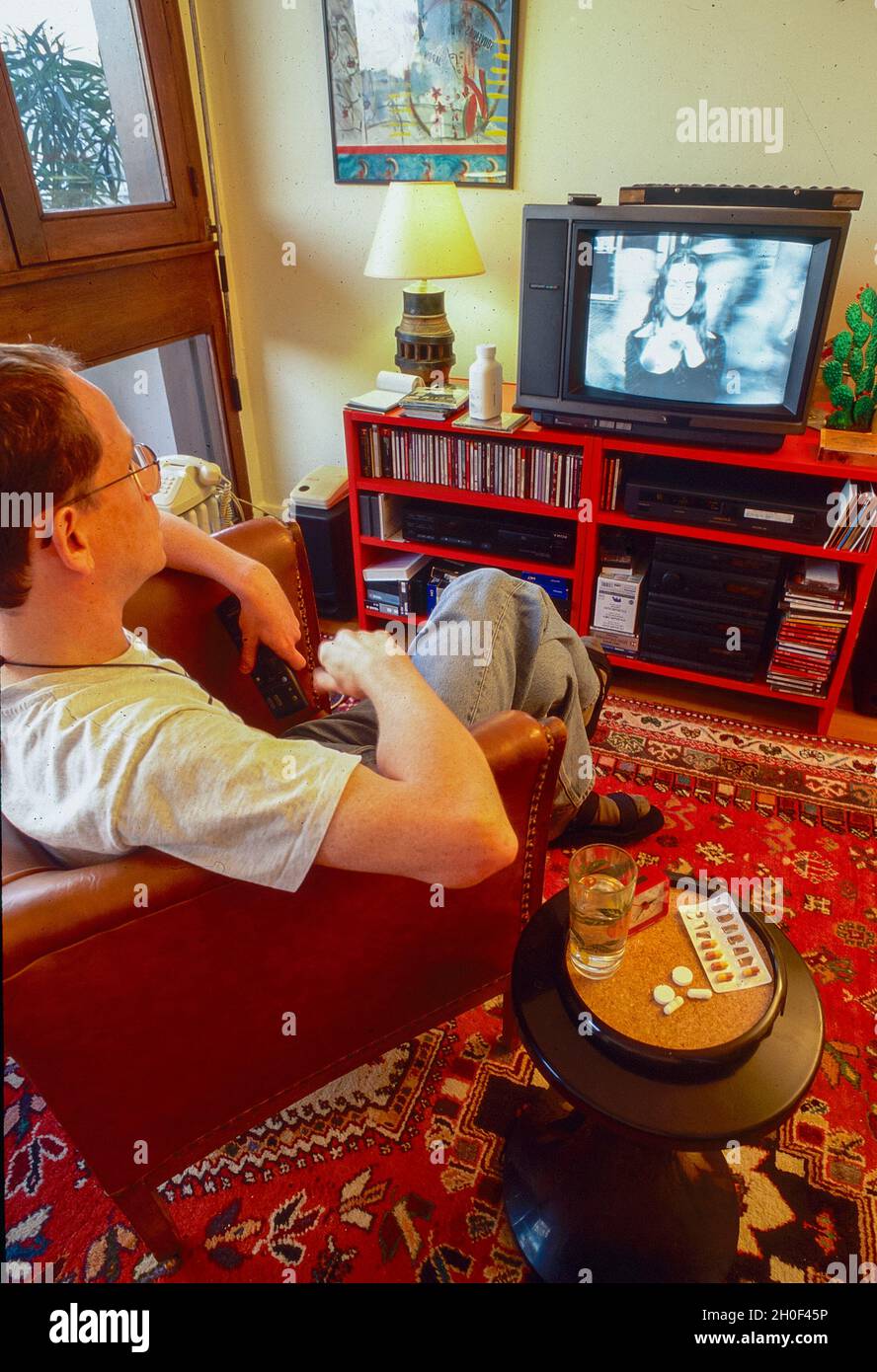Paris, Frankreich, Mann mit AIDS HIV-Medikamenten, Fernsehen zu Hause, Tri-Therapy-Drogencocktail, (Christophe Martet, Ex-Pres. Act Up Paris) Antivirus-Pillen, AIDS-Fernsehen der 1990er Jahre Stockfoto