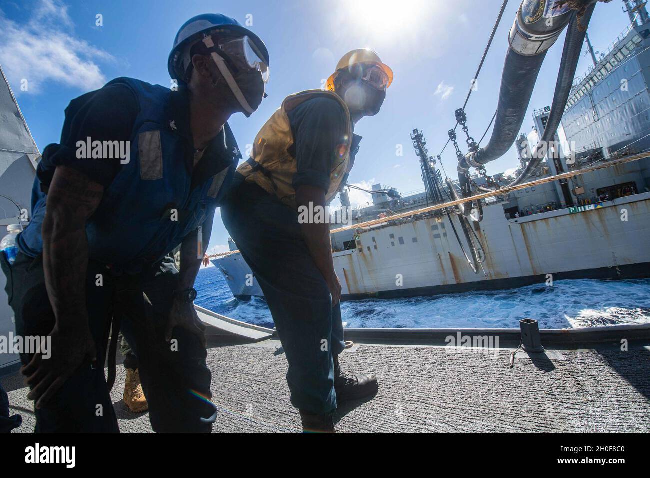 PHILIPPINISCHES MEER (Feb 23, 2021) Boatswain's Mate 3rd Class Jailyn Ellis, links, von Wilson, N.C., Und Boatswains Mate 2nd Class Tashawn Cooper aus Johnsonville, S.C., inspiziert die Verbindung der Kraftstoffleitung an Bord des Amphibientransportschiffes USS New Orleans (LPD 18) während eines Auffüllens auf See mit trockenem Fracht- und Munitionsschiff USNS Amelia Earhart (T-AKE 6) genau. New Orleans, Teil der America Amphibious Ready Group, ist zusammen mit der 31. Marine Expeditionary Unit im Verantwortungsbereich der 7. US-Flotte tätig, um die Interoperabilität mit Verbündeten und Partnern zu verbessern und als A r Stockfoto