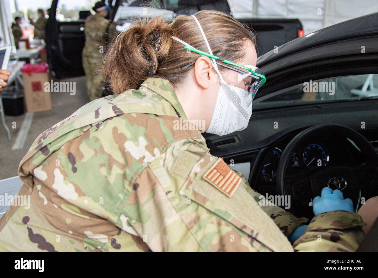 Lillian Snyder, Senior Airman der US-Luftwaffe, eine Medizinerin mit der 63. Stationären Einsatzmannschaft aus dem Luftwaffenstützpunkt Langley, VA., verabreicht einem Gemeindemitglied am 24. Februar 2021 im NRG Stadium in Houston, Texas, einen COVID-19-Impfstoff. Luftwaffe aus dem ganzen Land kam zusammen, um das Impfzentrum der Gemeinschaft medizinisch und logistisch zu betreuen. Das U.S. Northern Command setzt sich über die U.S. Army North weiterhin dafür ein, die Federal Emergency Management Agency im Rahmen der Reaktion der gesamten Regierung auf COVID-19 weiterhin flexibel und flexibel zu unterstützen. Stockfoto