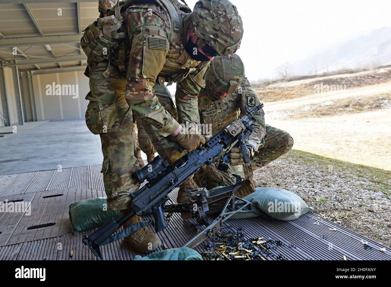 Fallschirmjäger der US-Armee, die der 173. Luftbrigade zugewiesen wurden, legen ihre M240B-Maschinenpistole während des Kampftrainings unter Covid-19-Präventionsbedingungen im Cao Malnisio Range in Pordenone, Italien, am 24. Februar 2021 ein. Die 173. Airborne Brigade ist die US Army Contingency Response Force in Europa, die in der Lage ist, einsatzbereite Truppen überall in den Verantwortungsbereichen der US-amerikanischen Kommandos Europa, Afrika oder Central‘ zu projizieren. Stockfoto