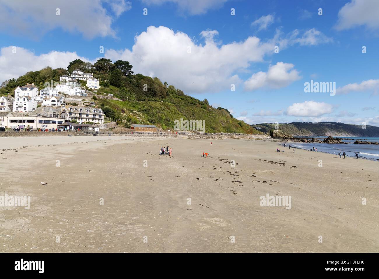 Looe Beach; ein paar Leute am Strand an einem sonnigen Herbsttag an der küste cornichs im Oktober, Looe, Cornwall UK Stockfoto