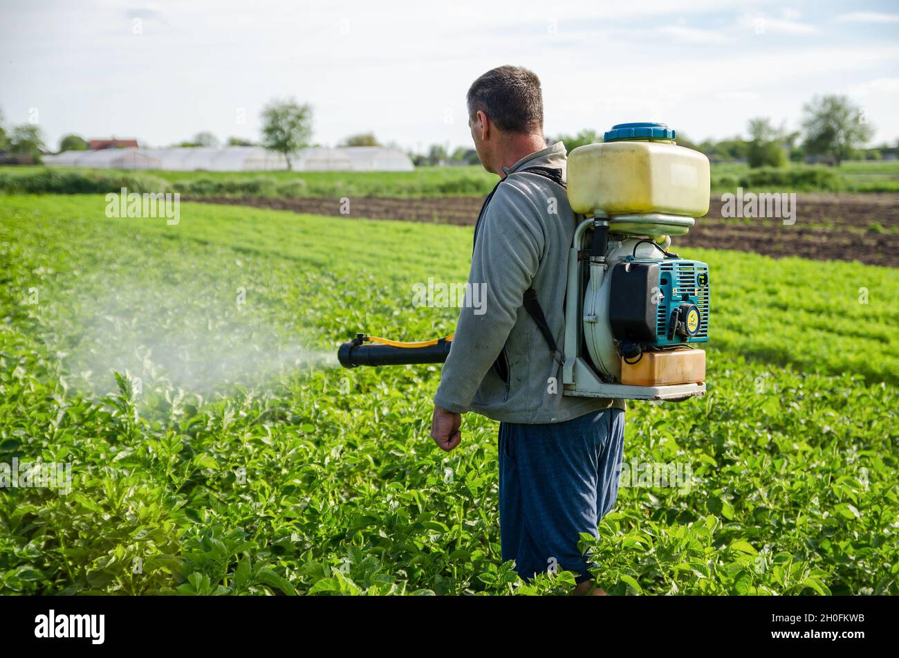 Kherson Oblast, Ukraine - 22. Mai 2021: Bauer sprüht eine Kartoffelplantage mit einem Sprüher. Wirksamer Pflanzenschutz von Kulturpflanzen gegen Insec Stockfoto