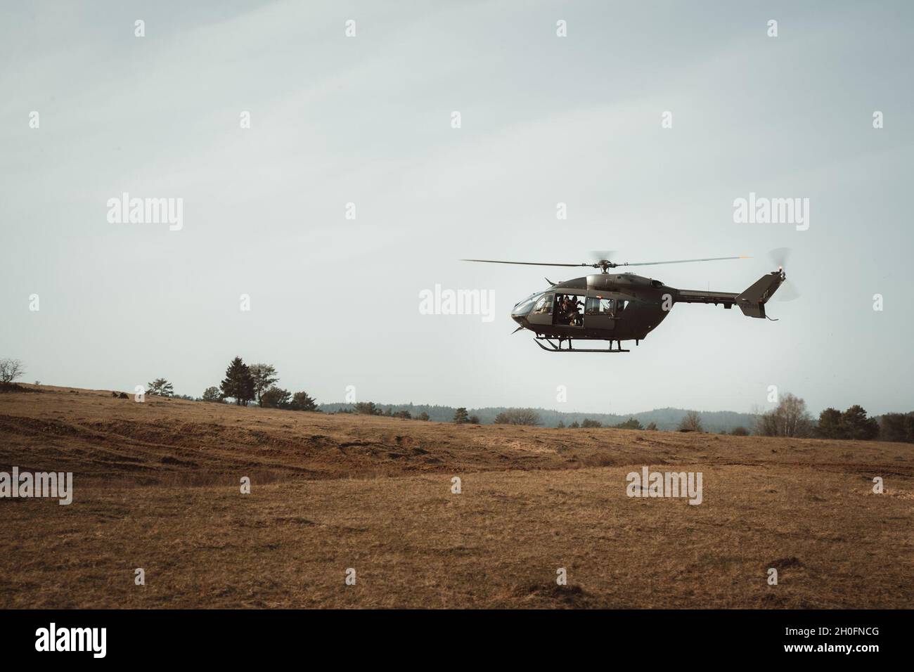 Ein italienischer Soldat für öffentliche Angelegenheiten in einem Hubschrauber der UH-72A Lakota fotografiert das Schlachtfeld im Trainingsgebiet Hohenfels, Deutschland, 26. Februar 2021. Combined Resolve XV verbessert die beruflichen Beziehungen und verbessert die Gesamtkoordination mit Verbündeten und Partnern während einer Krise. Stockfoto