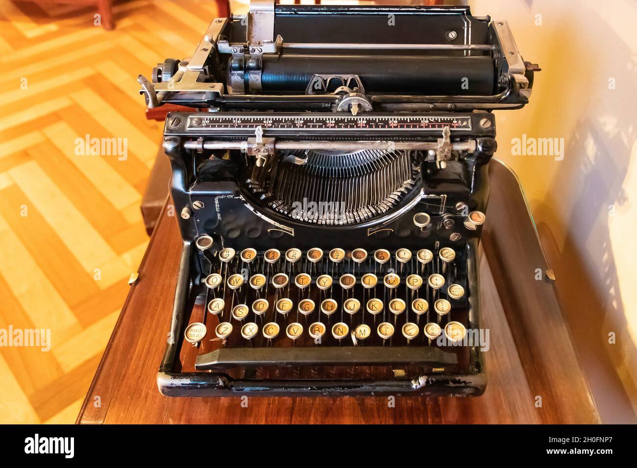 Eine alte Vintage-Schreibmaschine mit spanischer Tastatur über einem Holzschreibtisch. Stockfoto