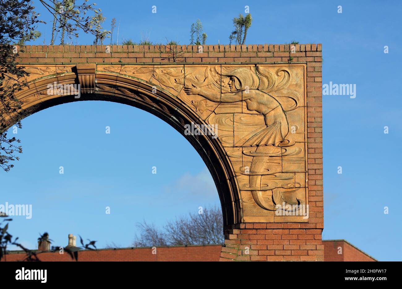 Terrakotta-Relief von J. W. Neatby von Meerjungfrauen (mit Flossen, Fischen und Wasserwellen), auf einem Torbogen bei der West Bridge, Leicester. Stockfoto