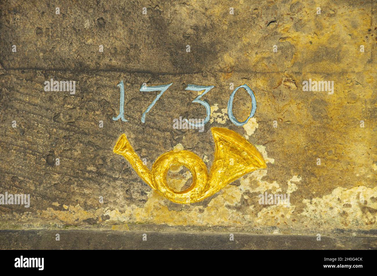 Posthorn und Jahr 1730 auf dem historischen kursächsischen Postmeilenstein in Moritzburg, Sachsen, Deutschland. Stockfoto