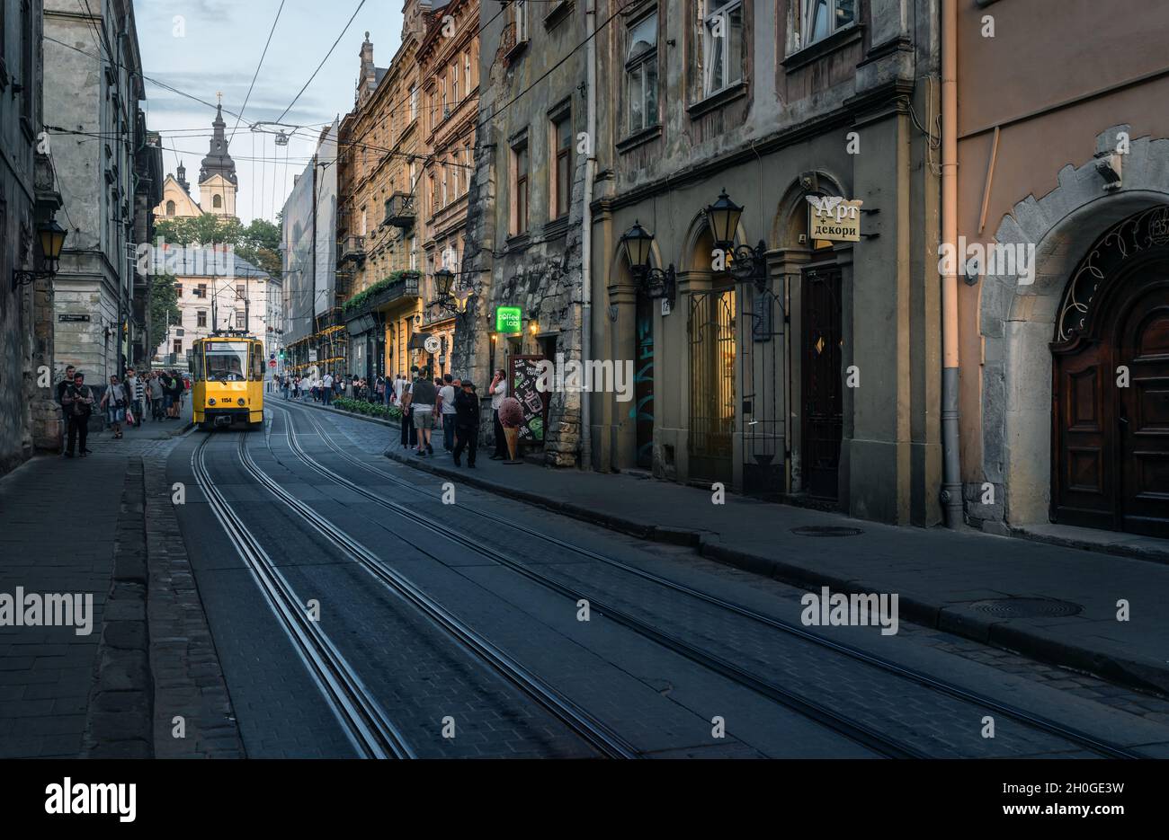 Ruska Straße mit der traditionellen gelben Straßenbahn und St. Michael Kirche im Hintergrund - Lviv, Ukraine Stockfoto