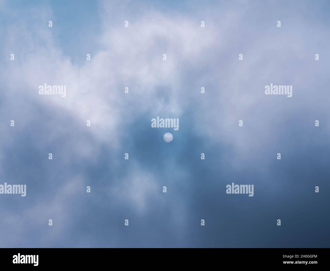 Stark aufsteigender Nebel, der das Sonnenlicht unterdrückt. Auf der Oberfläche der Sonne sind unten zwei Punkte zu sehen. Stockfoto