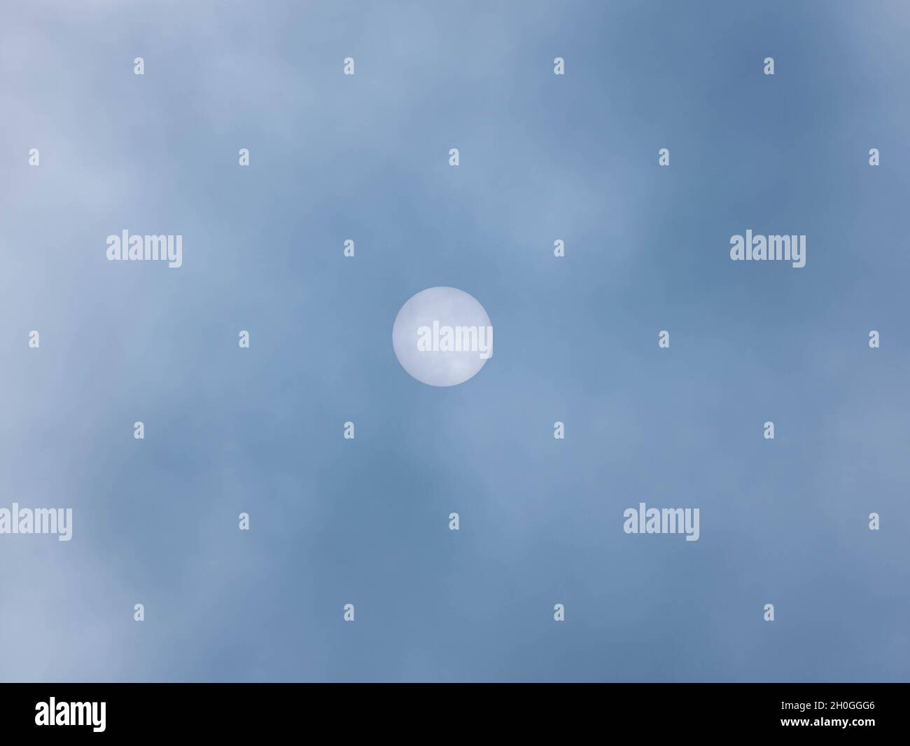Stark aufsteigender Nebel, der das Sonnenlicht unterdrückt. Auf der Oberfläche der Sonne sind unten zwei Punkte zu sehen. Stockfoto