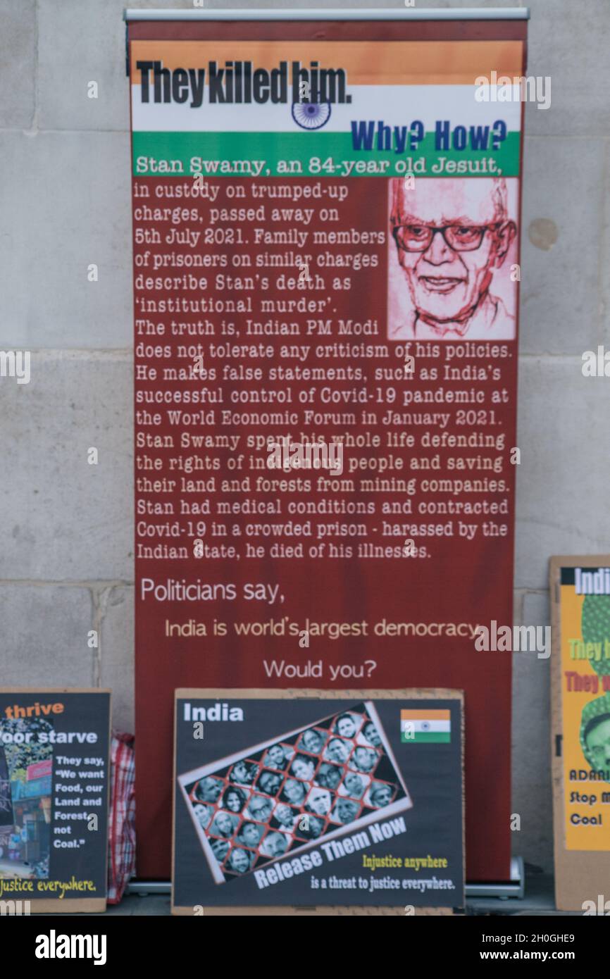 Trafalgar Square, London, England, Großbritannien 12. Oktober 2021 Columbus muss fallen! Neokolonialismus Muss Fallen! Indigene Völker protestieren gegen die Feier von Kolumbus. Symbolische Grabsteine mit den Namen und Bildern der Verstorbenen wurden auf dem Boden vor der Nationalgalerie aufgestellt, geschmückt mit Blumen und Kerzen. Im Anschluss an die Reden gab es eine Aufführung von Tänzern in indigenen Kostümen. Stockfoto
