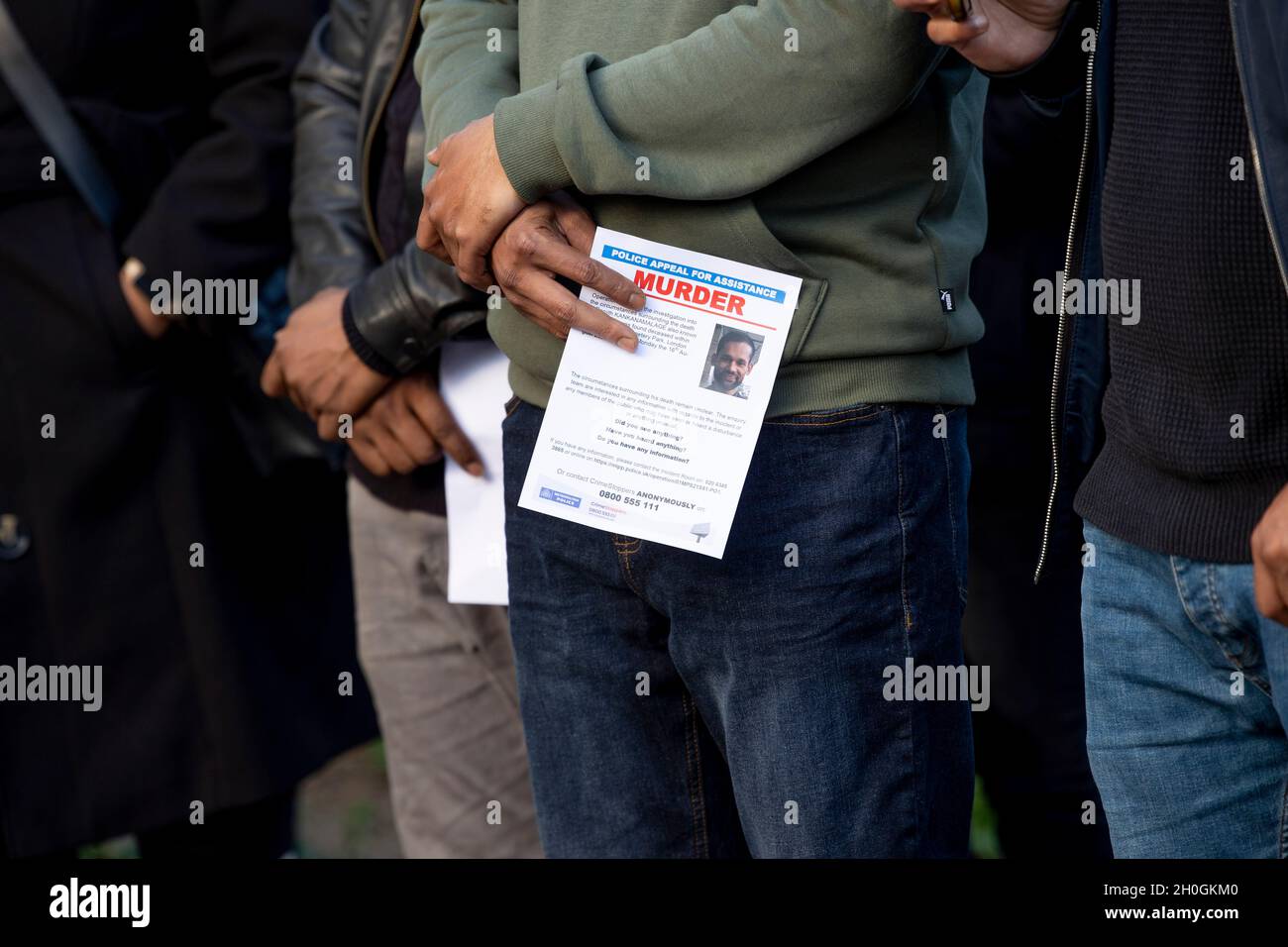 London, Großbritannien. Oktober 2021. Mitglieder der Öffentlichkeit sahen, wie sie die von der Met-Polizei verteilten Flugblätter hielten.Eine Mahnwache wurde von der örtlichen Gemeinde Tower Hamlets zum Gedenken an Ranjith Kankanamalage abgehalten, der im August in East London von einem homophoben Mörder getötet wurde. Die Met-Polizei stellte sich bei der Mahnwache vor und verteilte Flugblätter, um die Öffentlichkeit zu bitten, sich zu melden, wenn sie irgendwelche Informationen über den Vorfall haben. Kredit: SOPA Images Limited/Alamy Live Nachrichten Stockfoto