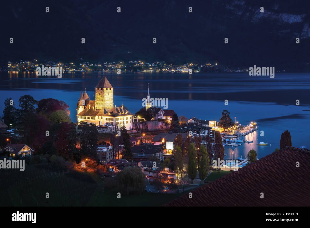 Luftaufnahme von Schloss Spiez und Schlosskirche am Thunersee bei Nacht - Spiez, Schweiz Stockfoto