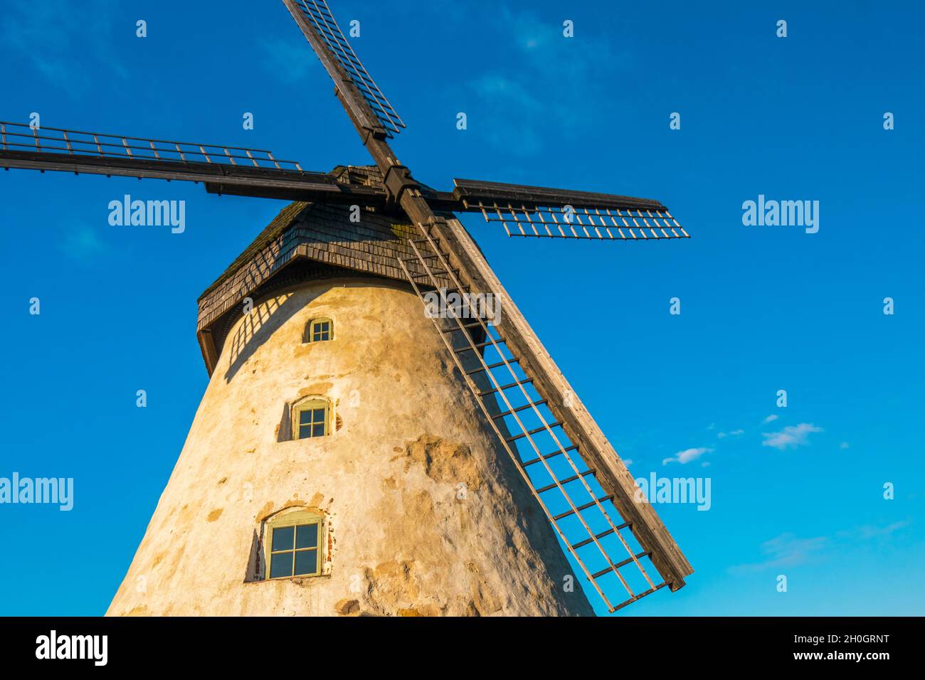 Die alte Windmühle von Āraiši mit ihren Flügeln im Gauja-Nationalpark, Lettland. Nahaufnahme der Holzklingen der holländischen Mühle an einem blauen, sonnigen Himmel. Stockfoto