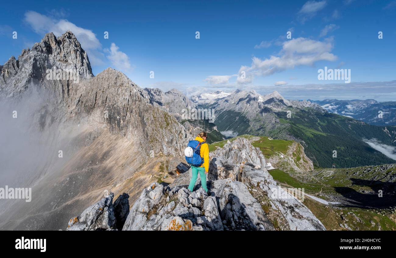 Wanderer auf einem Gipfel, westliche Törlspitze, Berge mit dramatischen Wolken, mittlere Zugspitze, hinter Patenkirchner Dreiterspitze, Wettersteingebirge Stockfoto