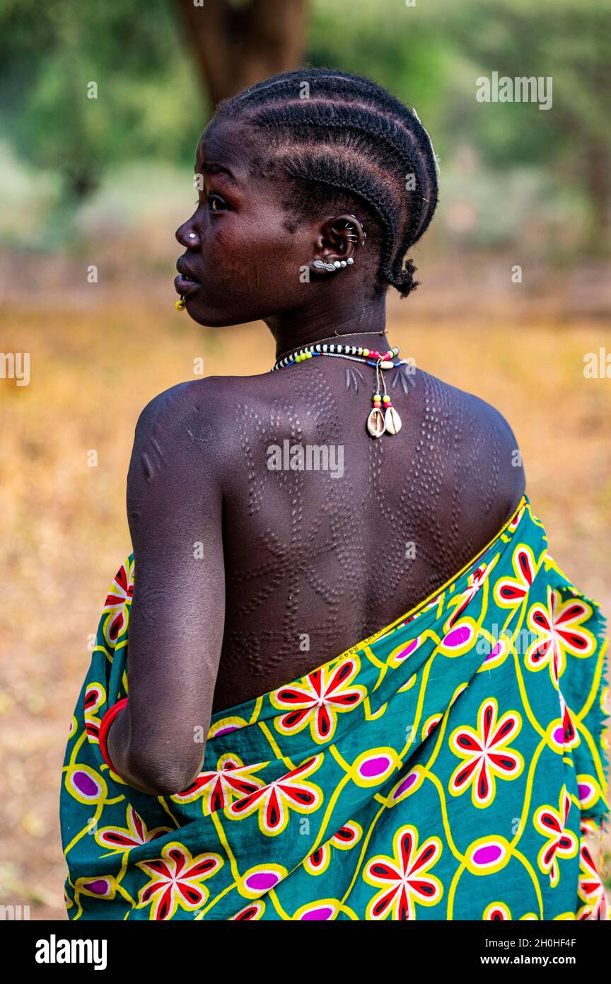 Traditionell gekleidete junge Mädchen aus dem Stamm der Laarim mit Körpernarben auf dem Rücken, Boya Hills, Eastern Equatoria, Südsudan Stockfoto