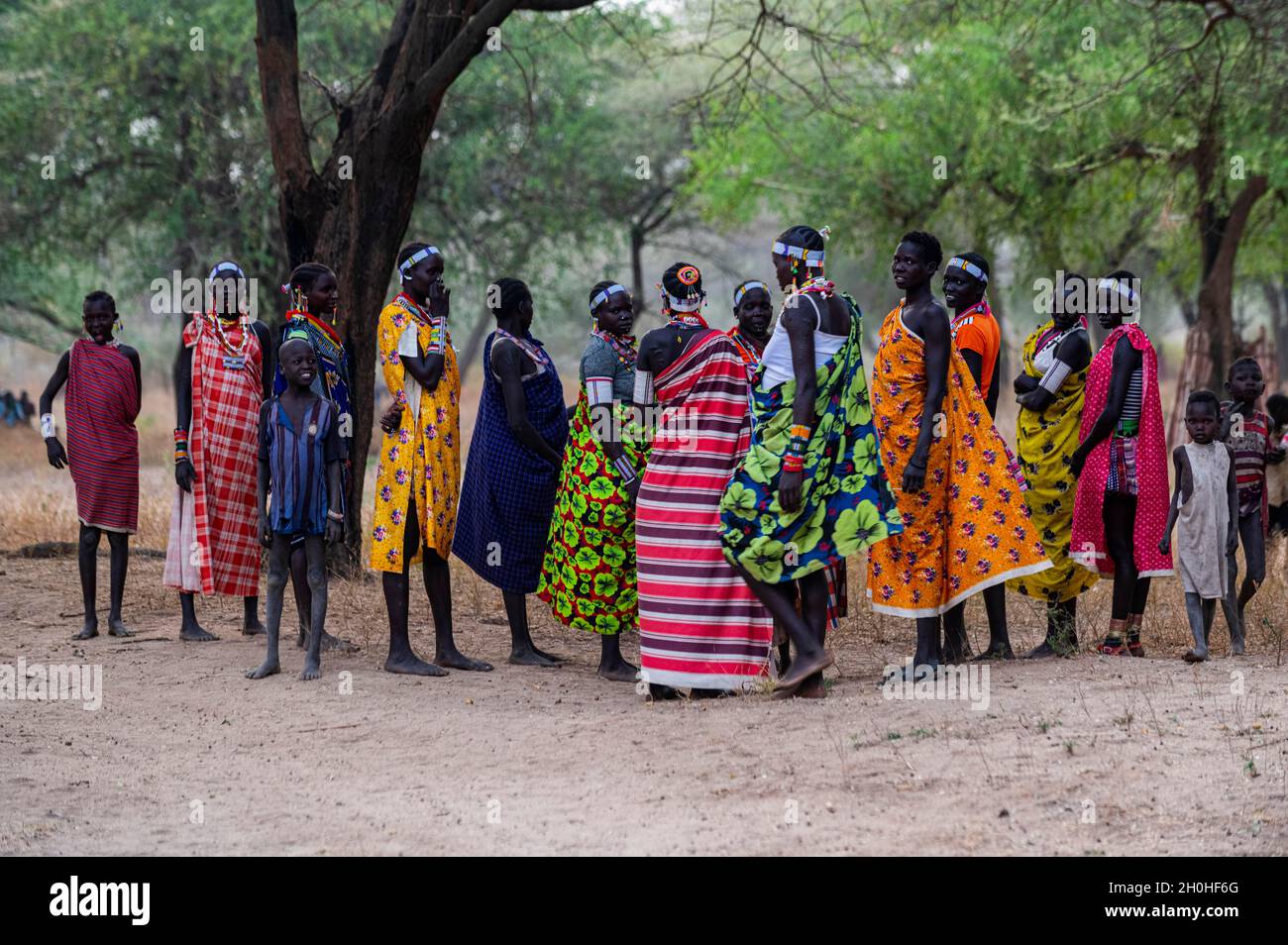 Traditionell gekleidete junge Mädchen aus dem Stamm der Laarim unterhalten sich unter einem Baum, Boya Hills, Eastern Equatoria, Südsudan Stockfoto