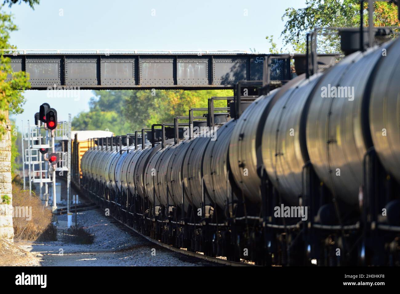 Wayne, Illinois, USA. Ein Güterzug der Canadian National Railway mit einer langen Reihe von Tankwagen fährt unter einem Viadukt. Stockfoto