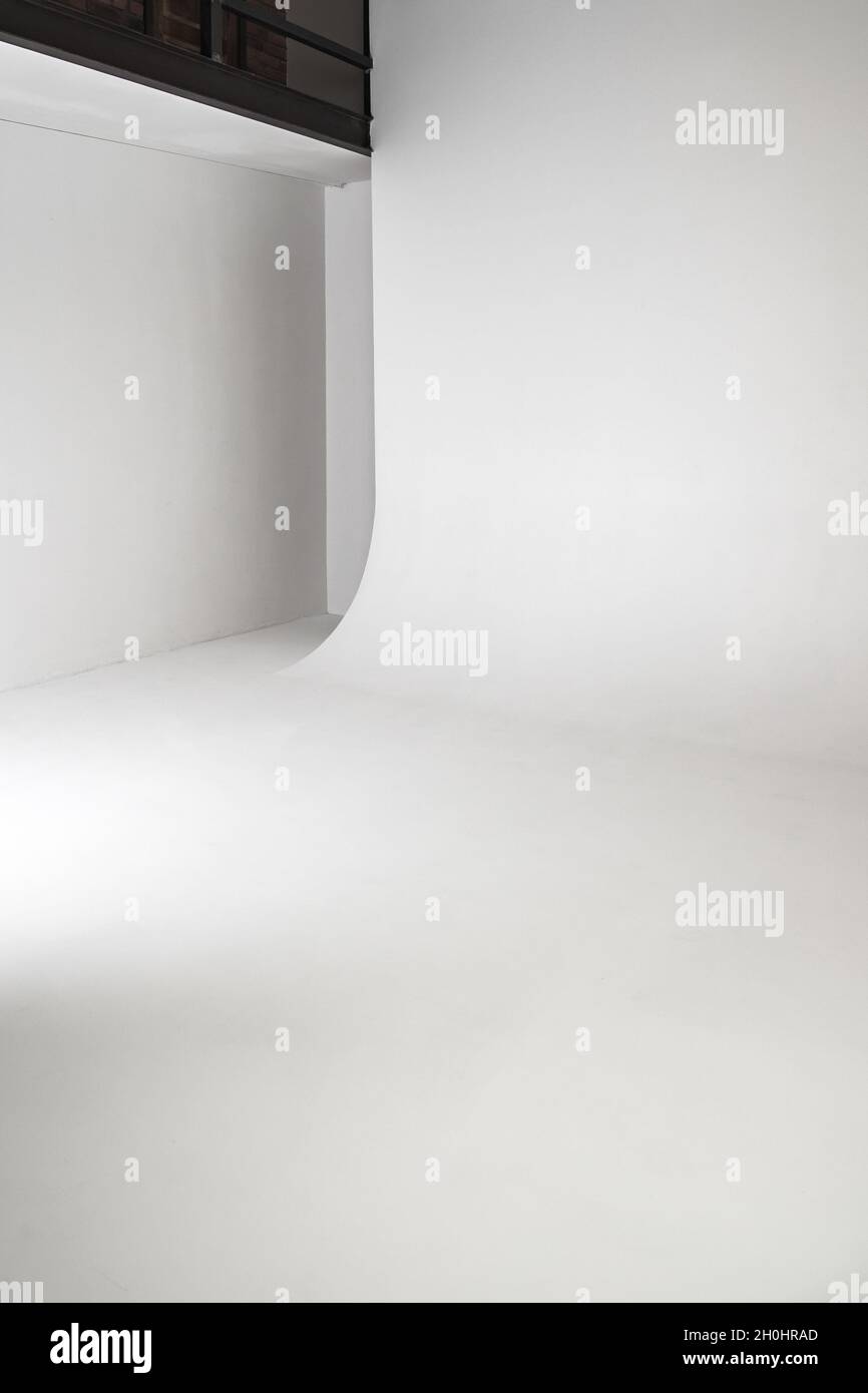 Abstrakt leer weiß Foto Studio Innenhintergrund. Vertikales Foto der Cyclorama-Struktur mit glattem Übergang zwischen horizontaler und vertikaler pl Stockfoto