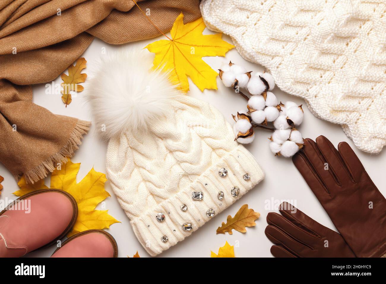Warme Herbst-Winter-Kleidung Accessoires auf weißem Hintergrund. Huthandschuhe Pullover Schal Schuhe. Flach liegend, Draufsicht Stockfoto