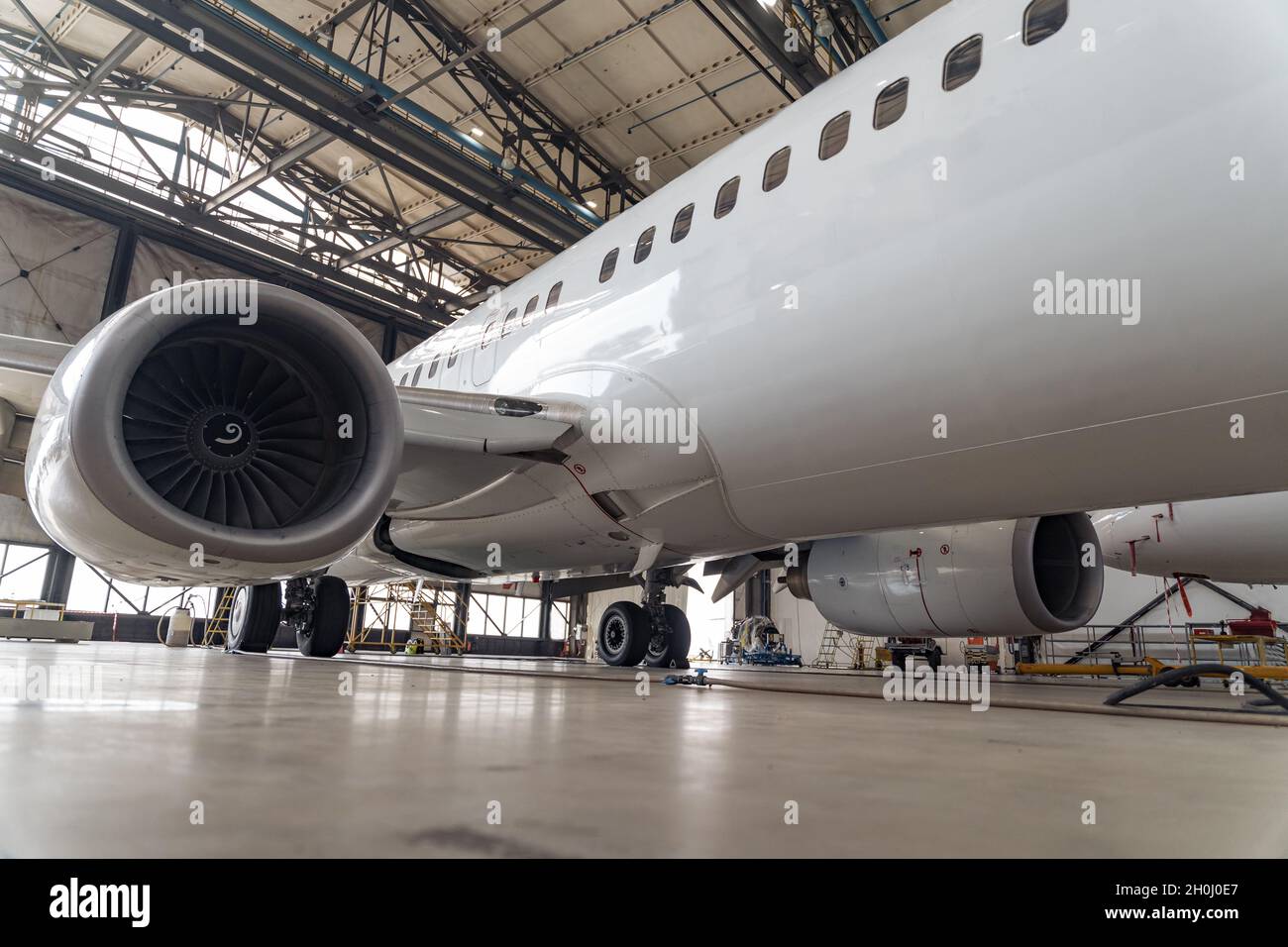 Rumpf eines großen weißen Flugzeugs in einem Flughafenhangar Stockfoto