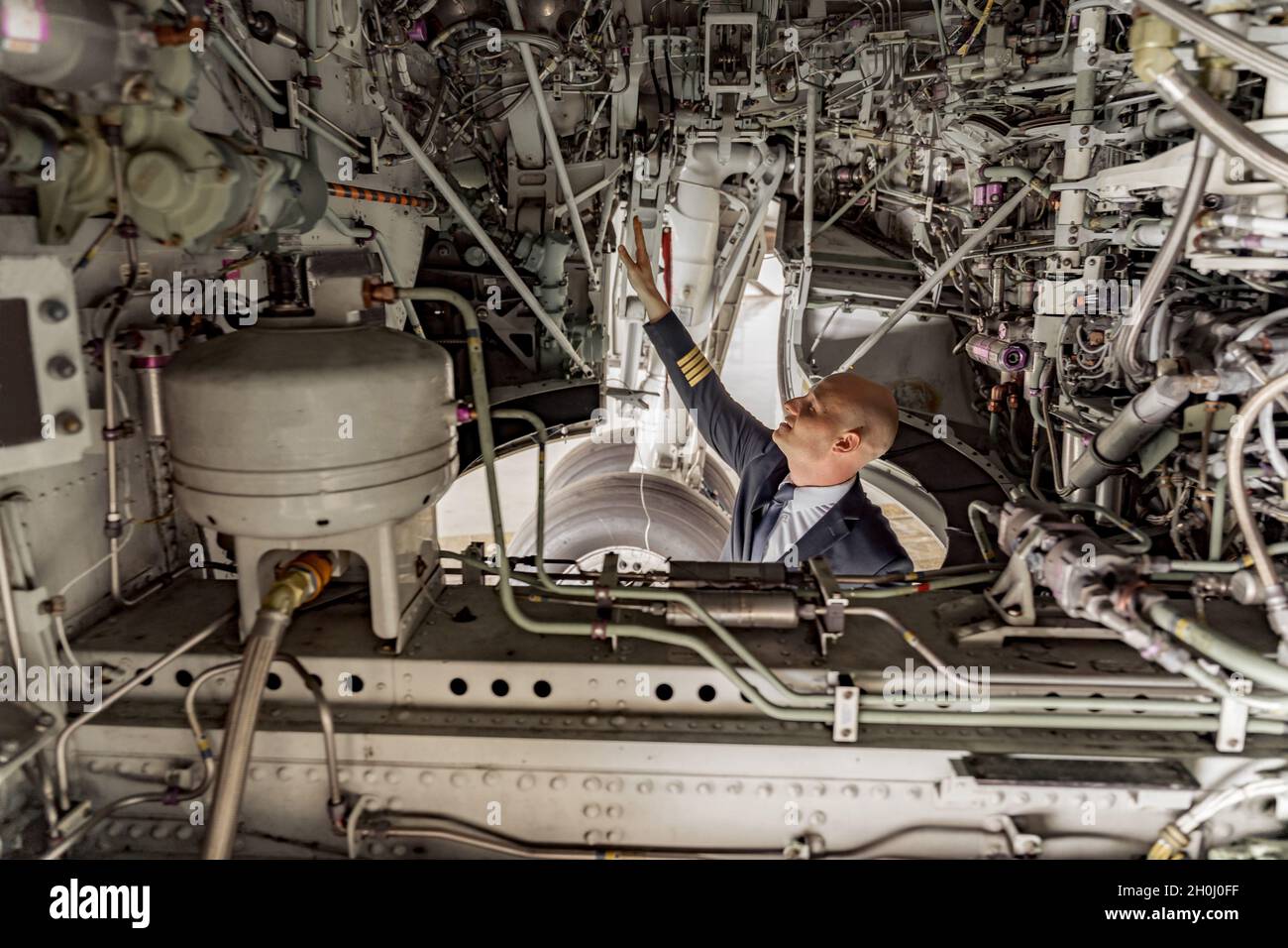 Pilot mit Blick auf den technischen Zustand des Flugzeugs im Hangar Stockfoto