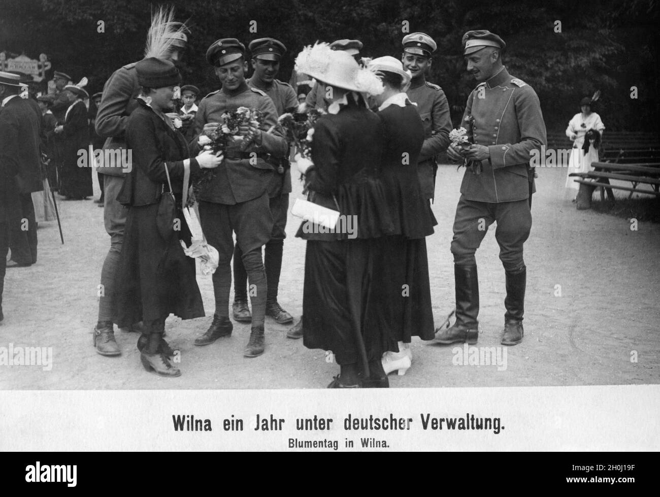 Blumentag im deutsch besetzten Vilnius: Junge Frauen reichen Blumensträuße an eine Gruppe deutscher Offiziere. [Automatisierte Übersetzung] Stockfoto