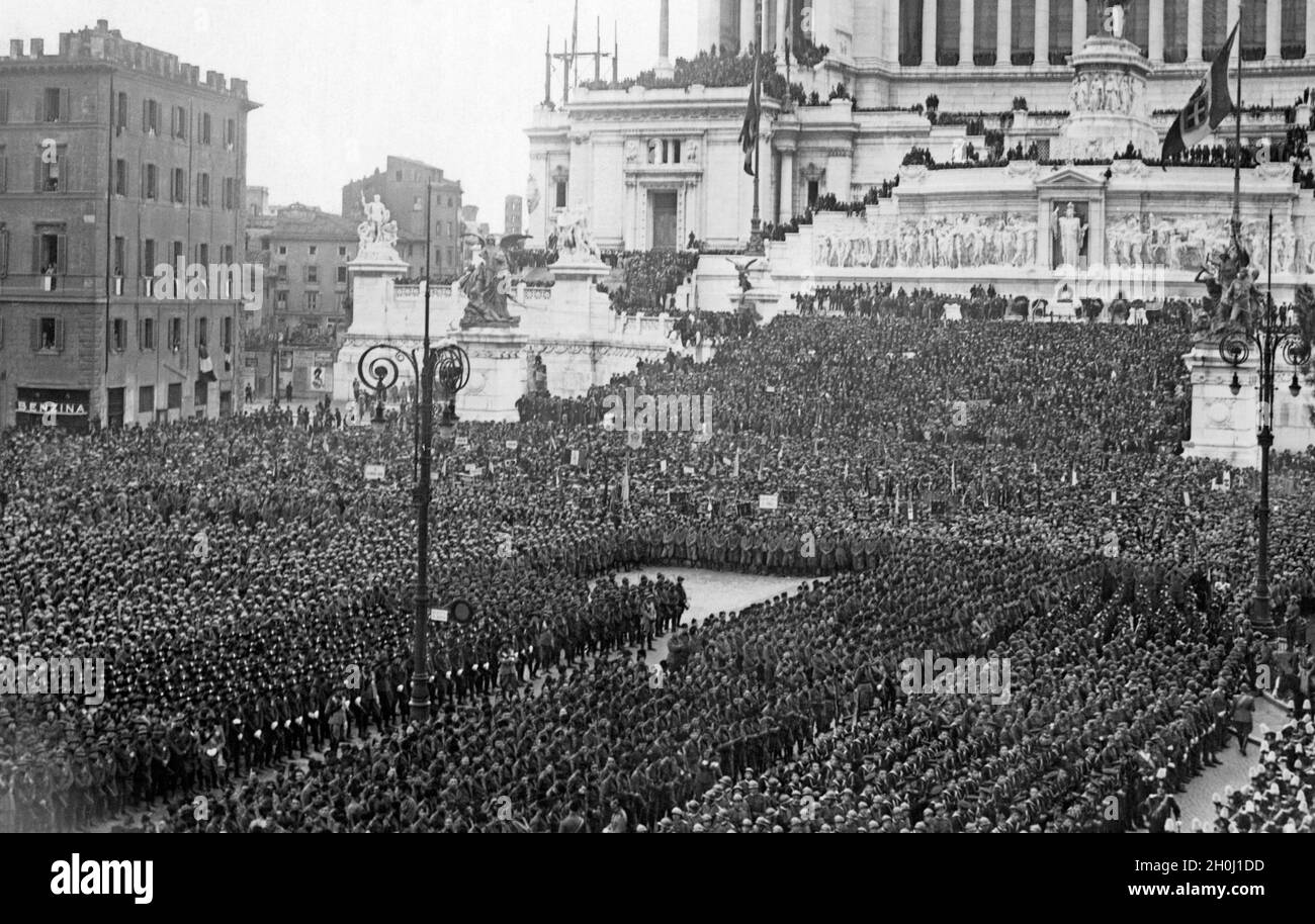 Tausende Soldaten der Infanterie, aber auch Matrosen, haben sich 1929 auf der Piazza Venezia in Rom zu einem marsch versammelt. Die Menschen breiteten sich bis zu den Stufen des Monumento Nazionale a Vittorio Emanuele II aus (rechts). [Automatisierte Übersetzung] Stockfoto