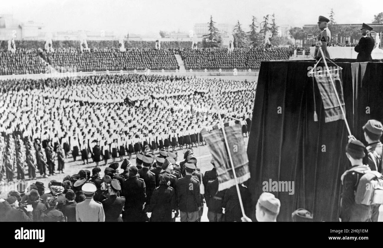 'Am 21. April 1940, der Legende nach, dem Gründungstag Roms im Jahr 753 v. Chr., hielt Benito Mussolini (oben rechts) eine Rede vor 30000 jungen Faschisten im Marmorstadion in Rom, in der er den Slogan ''Arbeit und Arm'' veröffentlichte. [Automatisierte Übersetzung]' Stockfoto