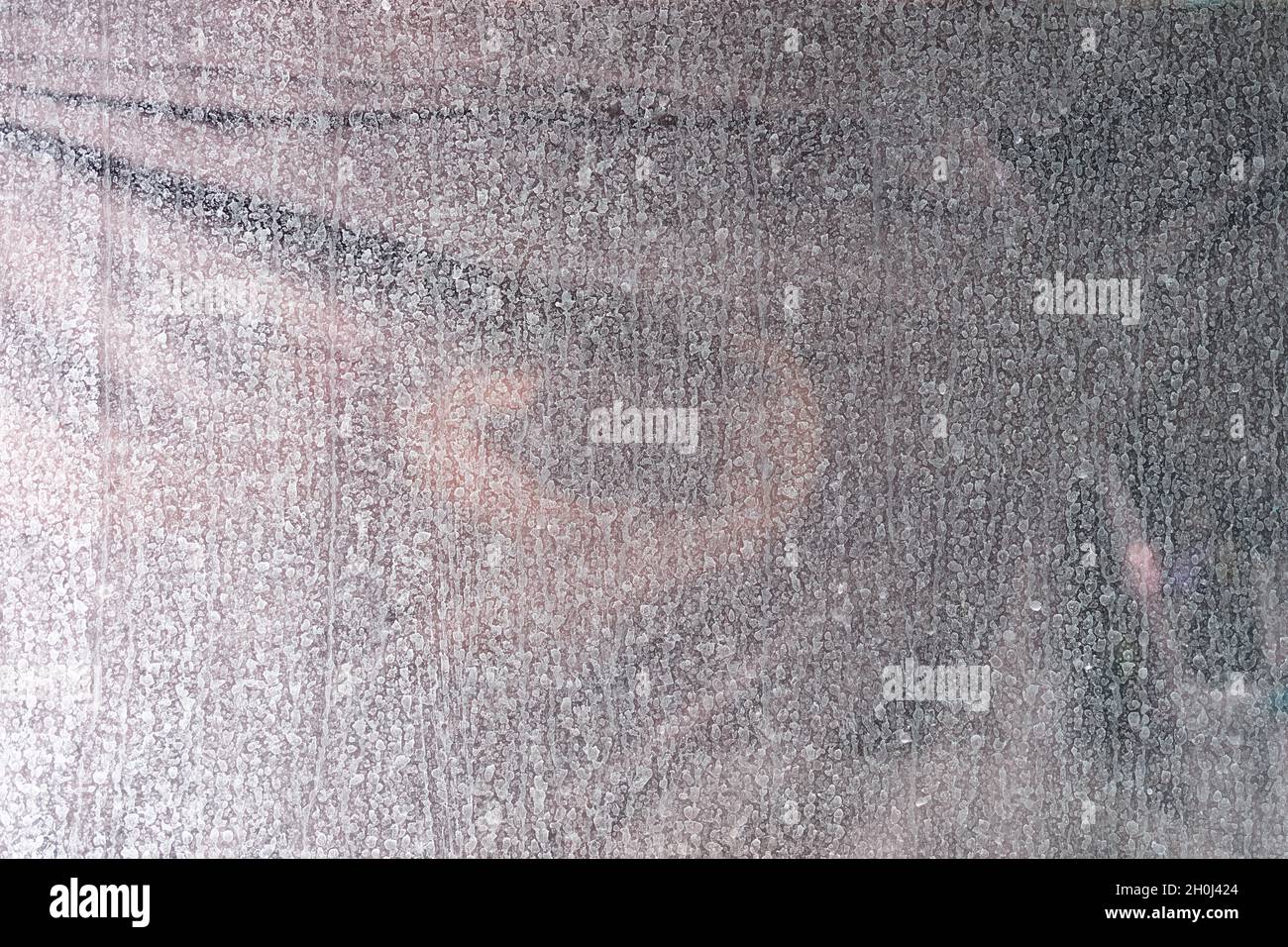 Schmutziges Glas Fenster mit vielen weißen, getrockneten Tropfen aus der Nähe Stockfoto