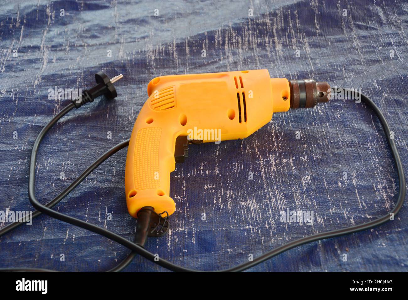 Elektrische Bohrmaschine mit schwarzem Kabel. Stockfoto