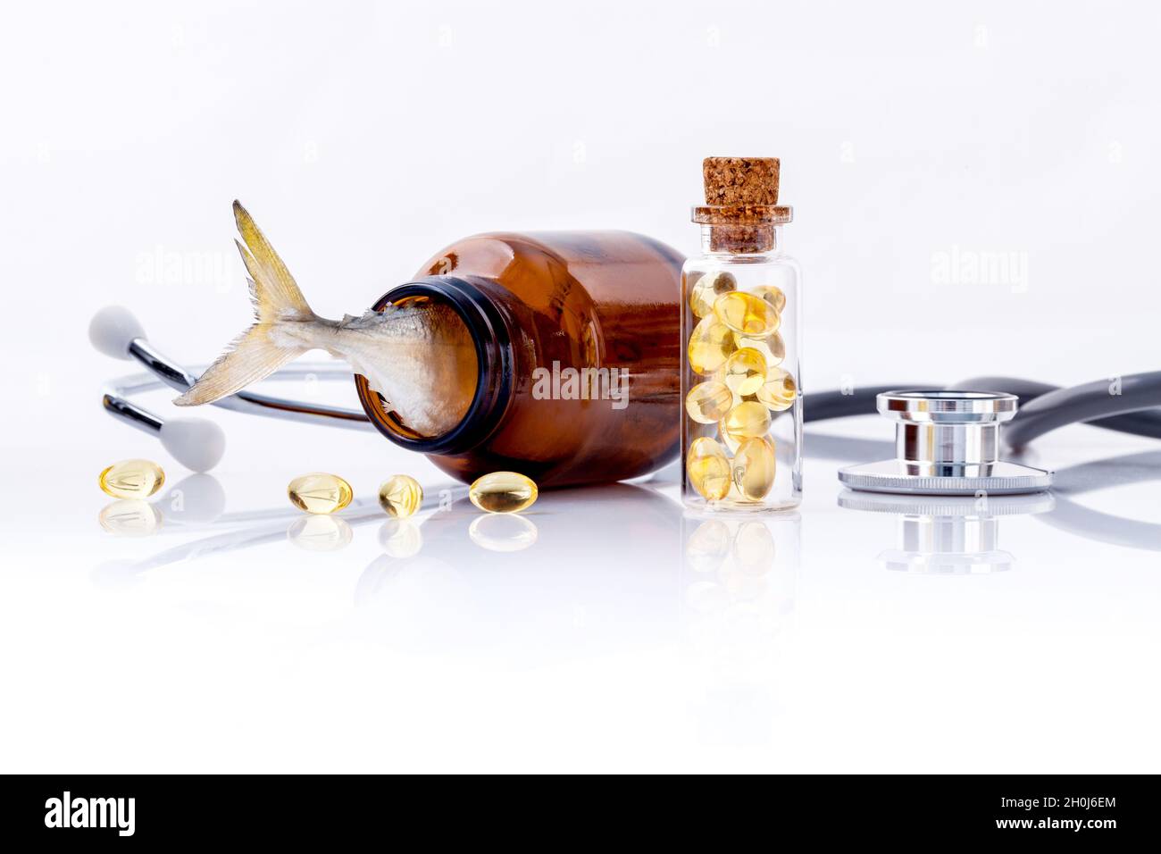 Leber Fischölkapseln in Flasche mit Stethoskop isoliert auf weißem Hintergrund. Stockfoto