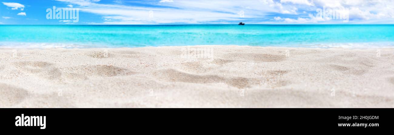 Wunderschönes tropisches Inselpanorama, weißer Sandstrand, türkisfarbenes Meerwasser, Wellen des Ozeans, sonnenblaue Himmelswolken, verschwommener Hintergrund, Sommerferien Stockfoto