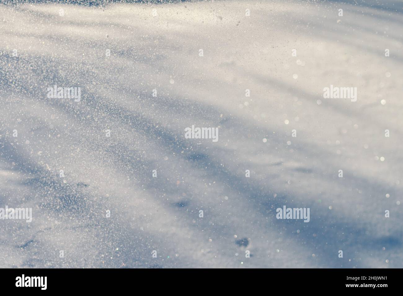 Schöne glitzernde schneebedeckte Landschaft Hintergrund, Streifen von Schatten und hellen Strahlen des Sonnenlichts. Platz für Text, saisonale Winterlandschaft Oberfläche mit Trick des Lichts, geblasene Kristalle von Schnee in der Luft Stockfoto