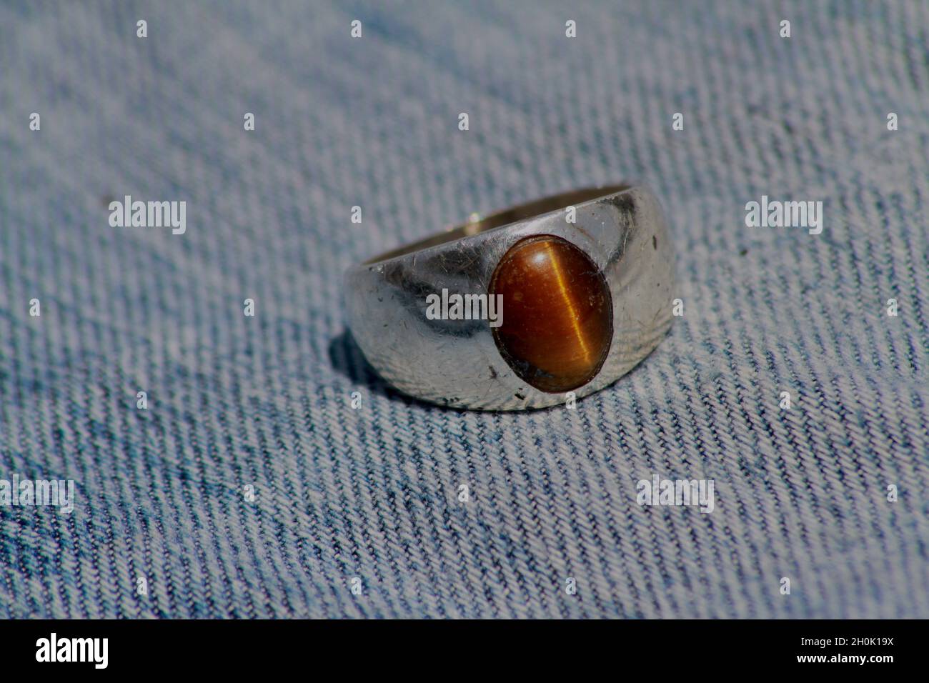 Nahaufnahme eines silbernen Ringes mit einem Edelstein aus Tiger's Eye Stockfoto