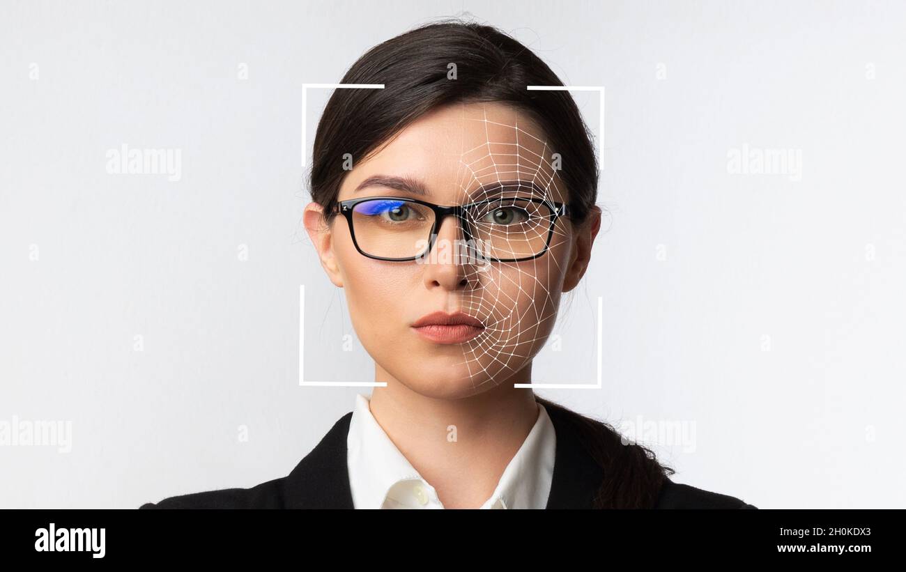 Seriöse, tausendjährige kaukasische Geschäftsfrau mit Brille und intelligenter Technologie für die Gesichtserkennung Stockfoto