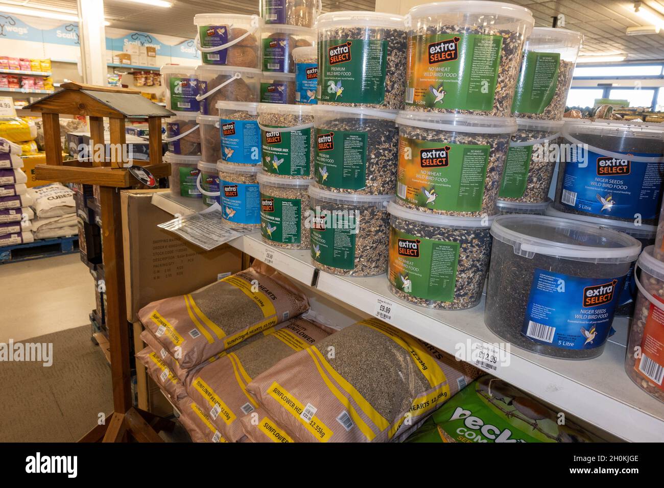 Große Beutel mit Wildvogelfutter in Säcken und Wannen auf einem Regal in einem Supermarkt Stockfoto